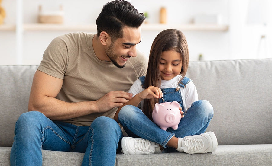 dad and daughter with piggy bank